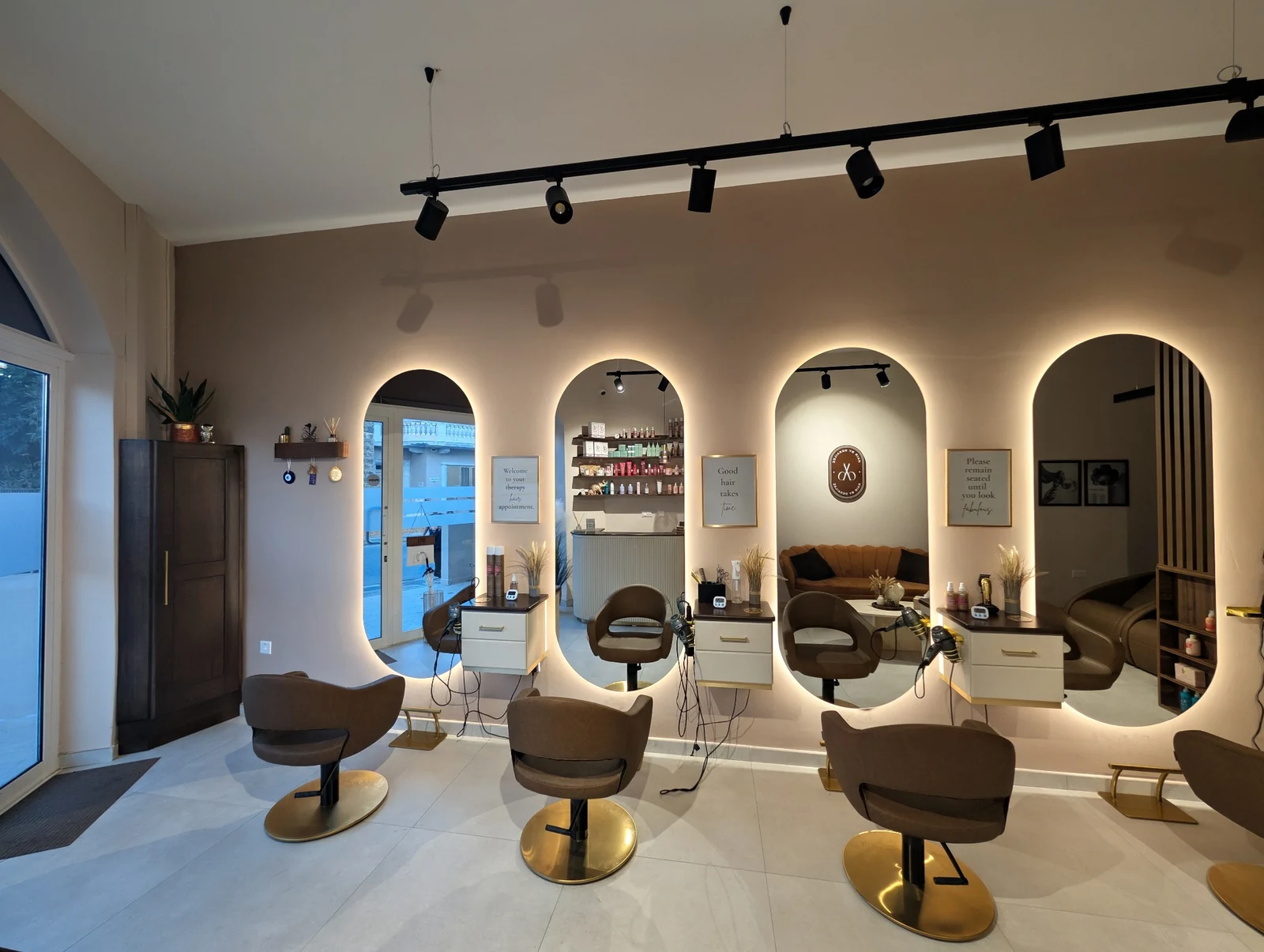 The same wall with four arched mirrors and styling chairs