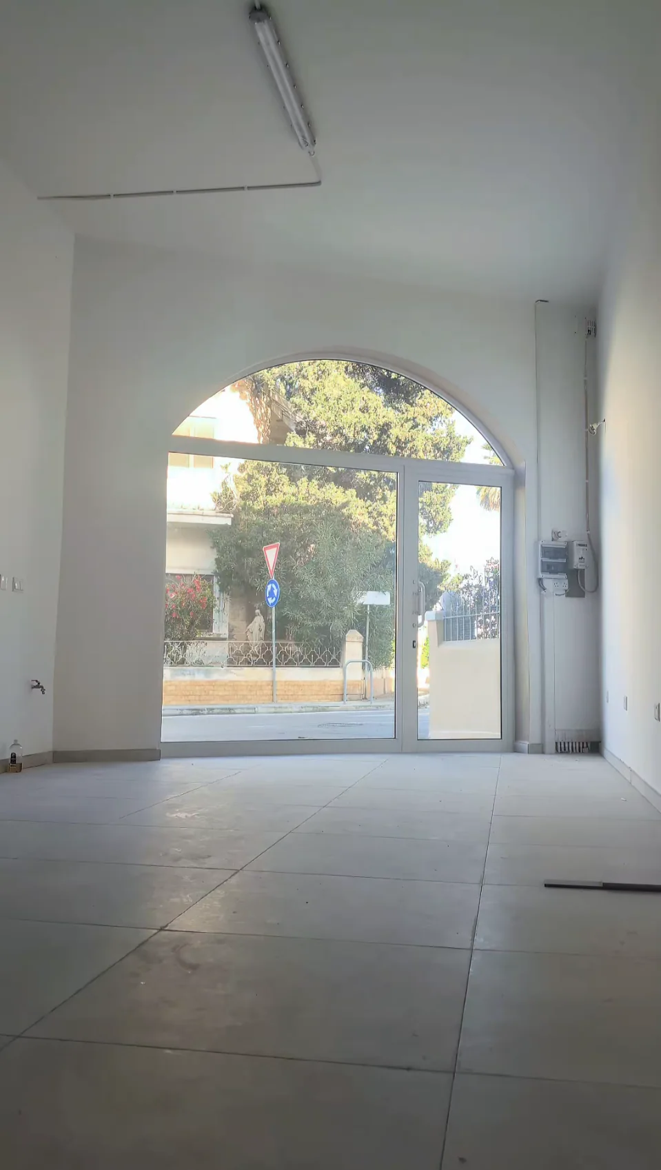 Empty salon before renovation, facing the arched entrance