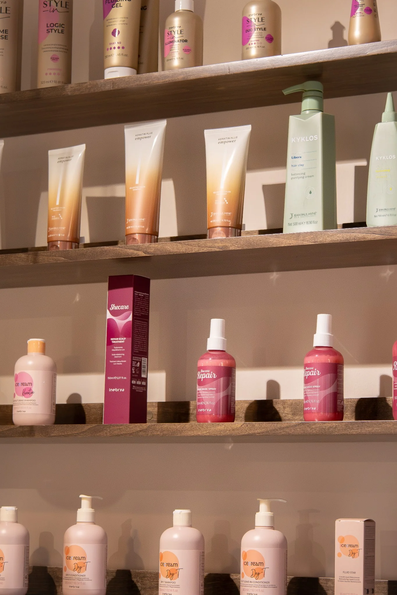 Warm styling stations and arched mirrors inside Hair by Desailee